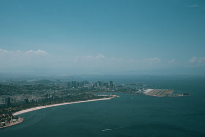 Aerial view of city buildings against blue sky