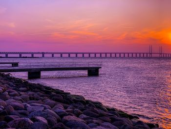 Pier over sea against sky during sunset