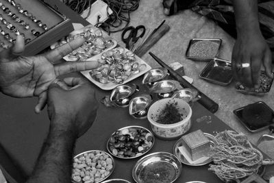 High angle view of person selling religious equipment to customer on table