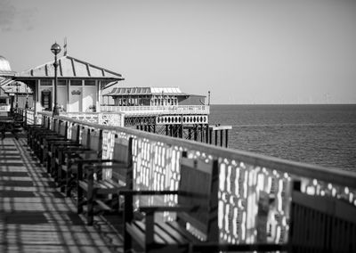 Pier by sea against clear sky