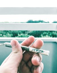 Close-up of hand holding cigarette