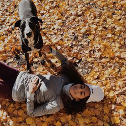 Portrait of young woman with dog lying down