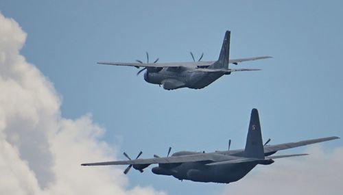 Low angle view of airplanes flying against sky