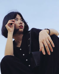 Midsection of woman standing against clear sky