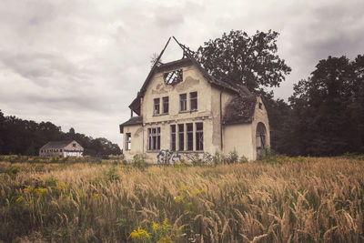 Abandoned house on field against sky