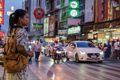 Side view of woman standing on street