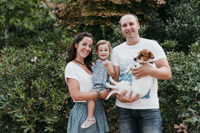 Smiling family standing in public park