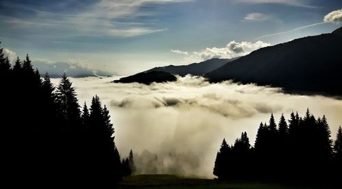 Clouds against silhouette mountain range