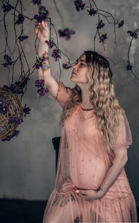 Portrait of woman standing against wall