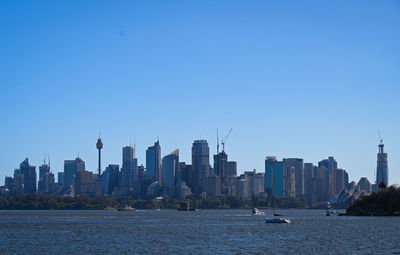 Modern buildings in city against clear blue sky