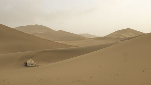 Scenic view of desert against sky with human inhabitance 