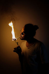 Rear view of woman holding sparkler at home