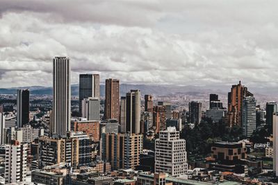 View of cityscape against cloudy sky