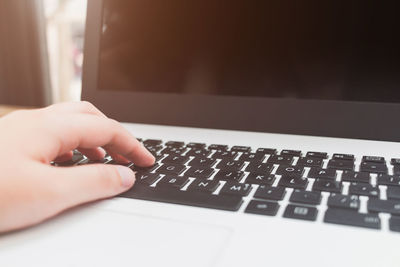 Close-up of businesswoman using laptop on table at sidewalk cafe