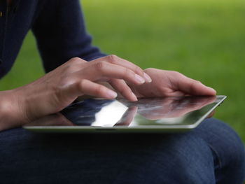 Midsection of person using digital tablet