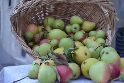 Close-up of apples spilling from basket on table