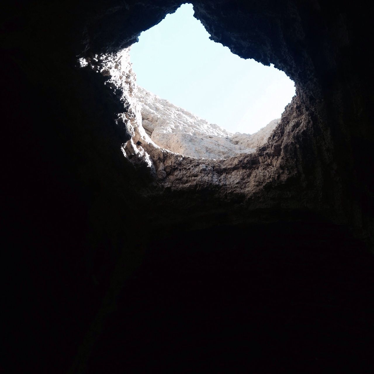 low angle view, tranquility, cave, nature, mountain, clear sky, dark, copy space, beauty in nature, silhouette, indoors, sky, tree, rock formation, scenics, rock - object, tranquil scene, close-up, no people, geology
