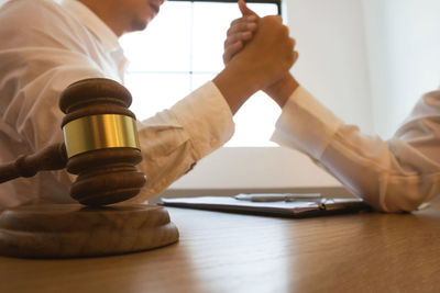 Midsection of man holding glass table