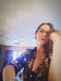 Portrait of young woman sitting on ceiling