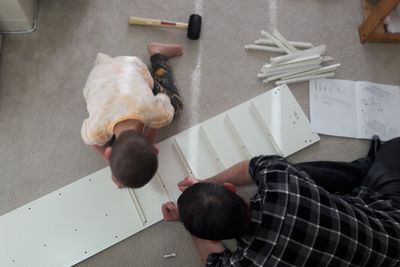 High angle view of father and daughter making cabinet at home