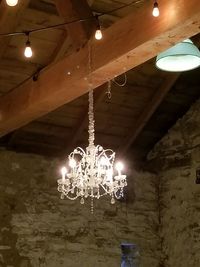 Low angle view of illuminated chandelier hanging on ceiling