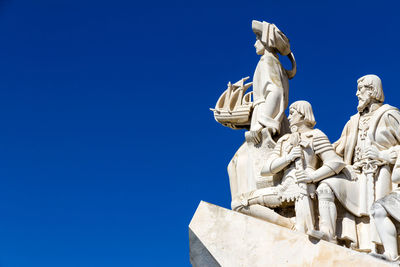 Low angle view of statue against blue sky