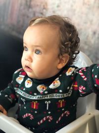 Close-up of cute baby girl sitting on high chair