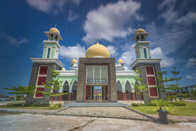 Facade of building against cloudy sky