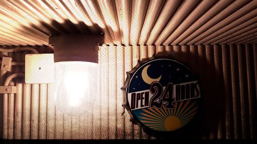 Low angle view of illuminated lamp on wall