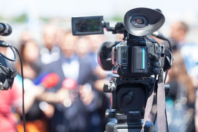 Close-up of television camera filming interview in city