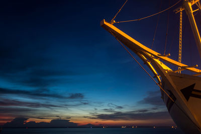 Low angle view of illuminated sea against sky at sunset