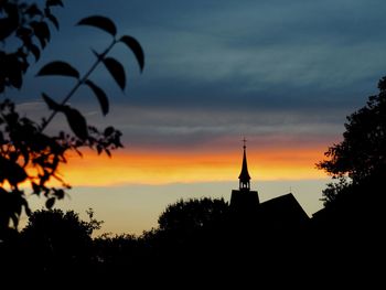 Silhouette of building against sky during sunset