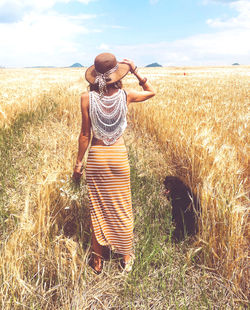 Rear view of woman standing on field