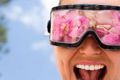 Woman wearing protective googles filled up with flowers