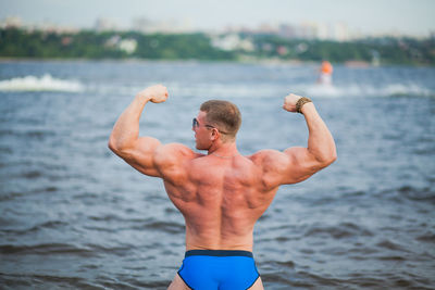 Midsection of shirtless man in water