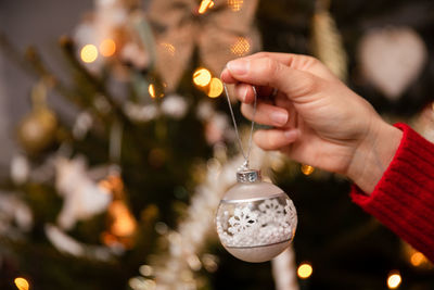 Close-up view while decorating a live christmas tree for christmas.