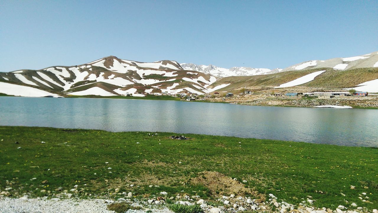 grass, clear sky, mountain, tranquil scene, tranquility, blue, beauty in nature, scenics, water, copy space, landscape, nature, field, grassy, animal themes, sky, day, lake, non-urban scene, mountain range