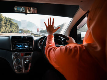 Rear wiew of a woman driving and talking on the phone hands free