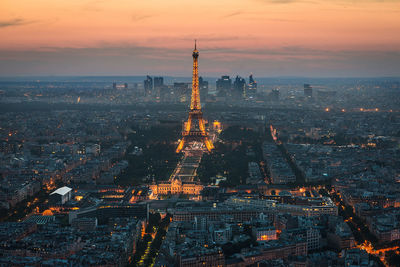 High angle view of cityscape with illuminated eiffel tower during sunset