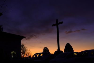 Low angle view of silhouette cross against sky at sunset