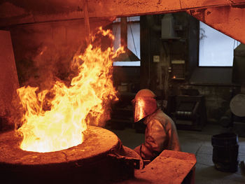 Industry, worker at furnace during melting copper, wearing a fire proximity suit