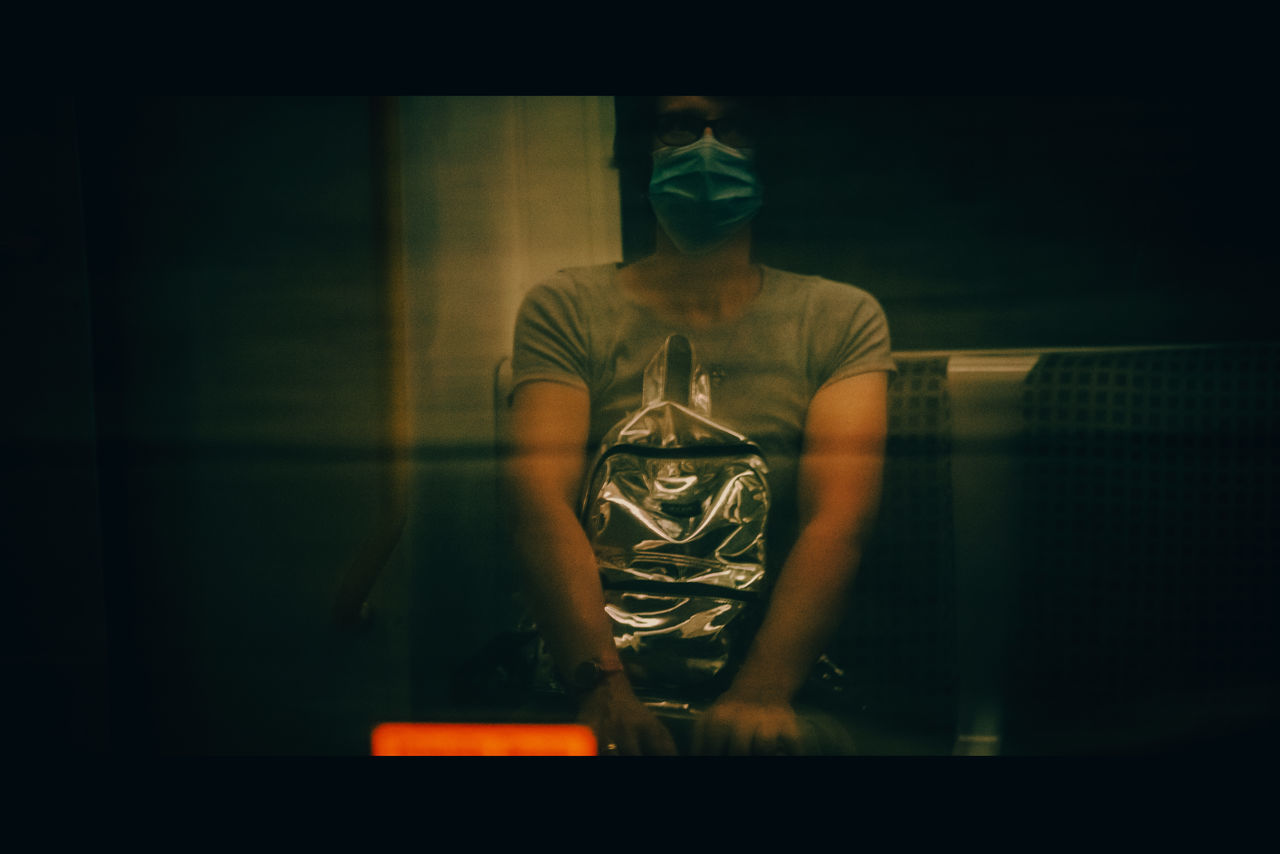 YOUNG MAN STANDING BY WINDOW