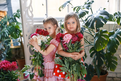 Portrait of girl standing by flowering plants