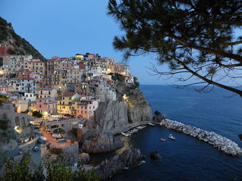 Aerial view of townscape by sea against clear sky