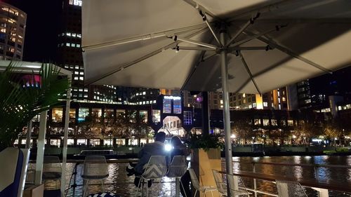 Rear view of people on illuminated city at night