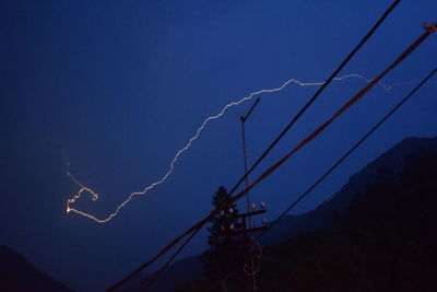 Low angle view of crane against sky at night