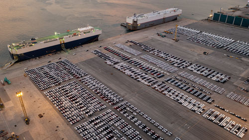 Aerial view of new cars parked at the parking area of automobile factory. waiting for roro transport