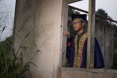 Man in graduation gown standing outdoors