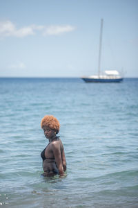 Man in sea against sky