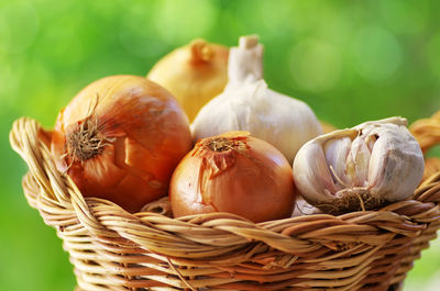 Close-up of garlic and onions in wicker basket